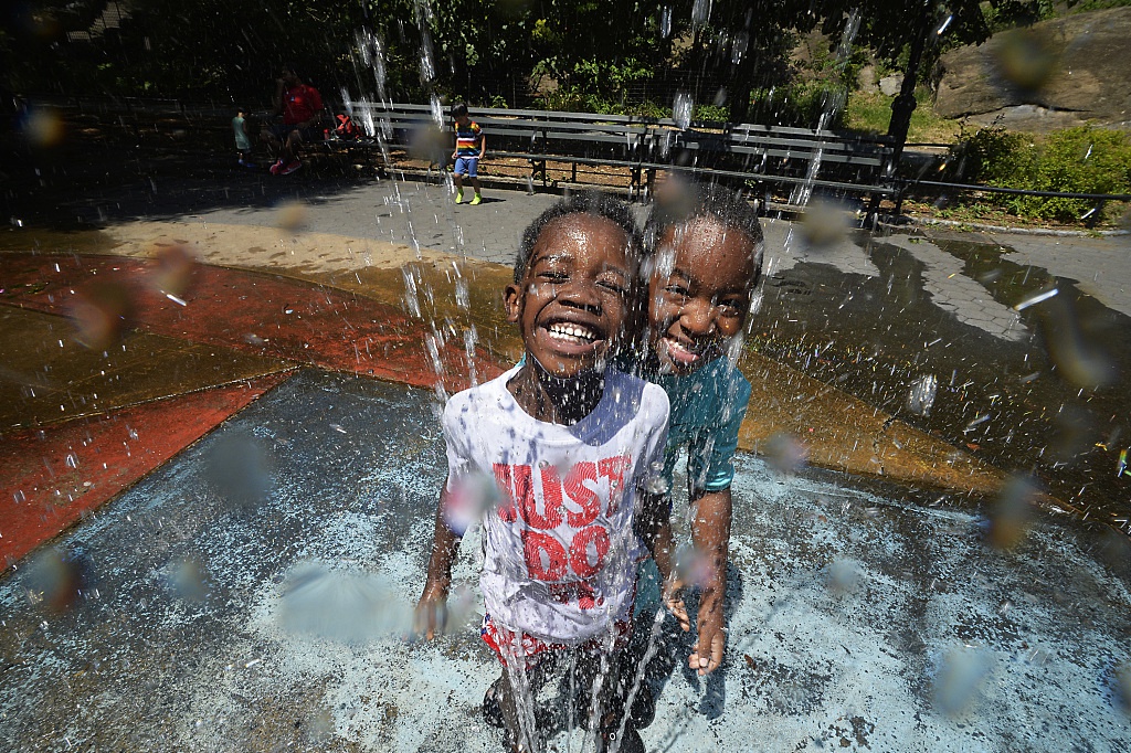 11 纽约迎来夏季热浪 儿童在喷泉池里玩水消暑