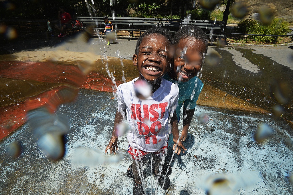 11 纽约迎来夏季热浪 儿童在喷泉池里玩水消暑