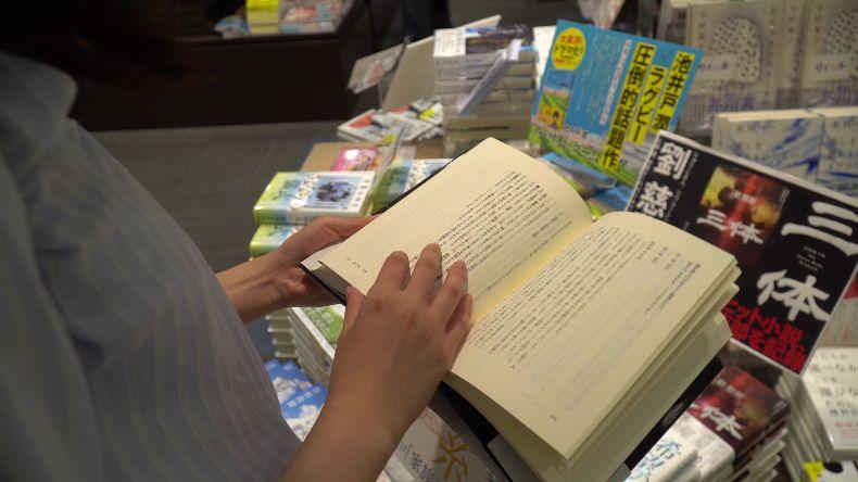 日本读者在书店翻看《三体》日文版一书。 来源： 视频截图