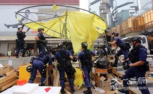 2014年12月，身穿蓝色制服，又称“速龙小队”的警方特别战术小队人员，拆除金钟“占领区”路障。（图片来源：大公报）