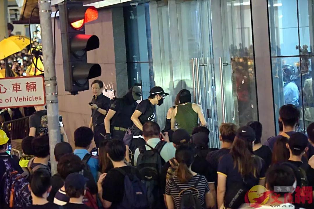 杨逸朗(绿色背心)在6月26日晚疑尝试冲击警总玻璃门。来源：香港文汇网(资料图片)