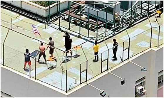 8名男生手持美国旗在学校天台进行疑似暴力冲击集训。(图片来源：大公网)
