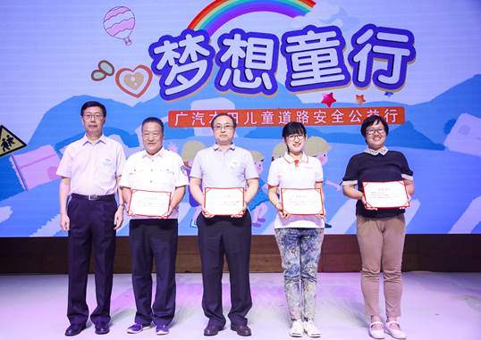 中国道路交通安全协会秘书长王京(左一)给讲师授牌