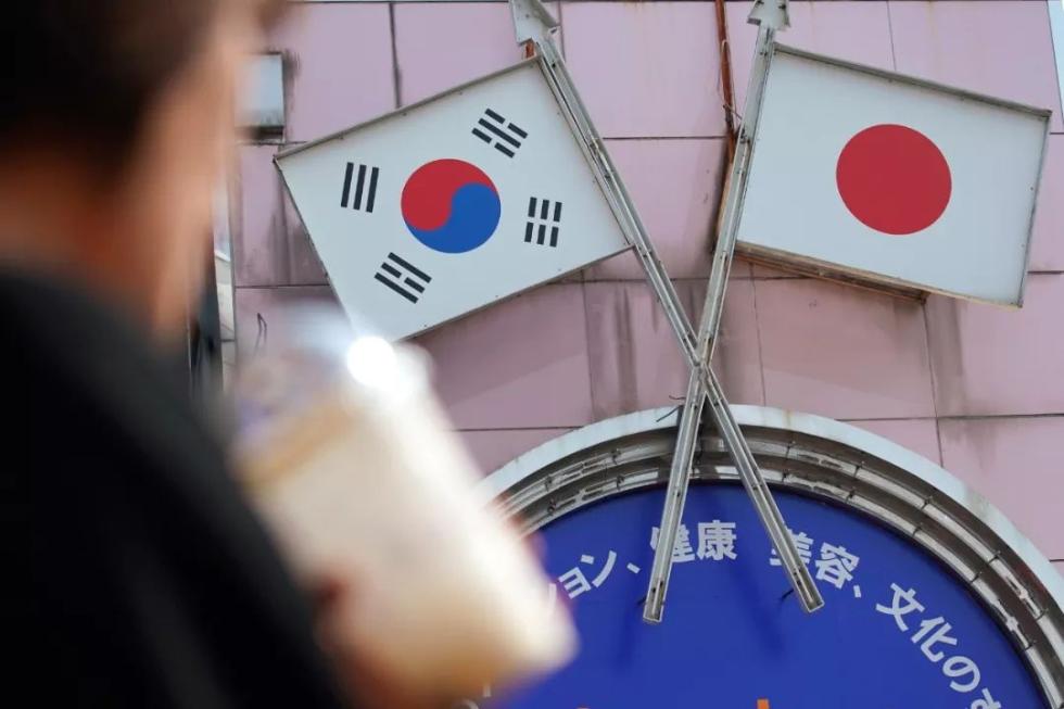 8月2日，在日本首都东京的新大久保，行人从标有日本和韩国国旗的广告牌前走过。新华社/美联