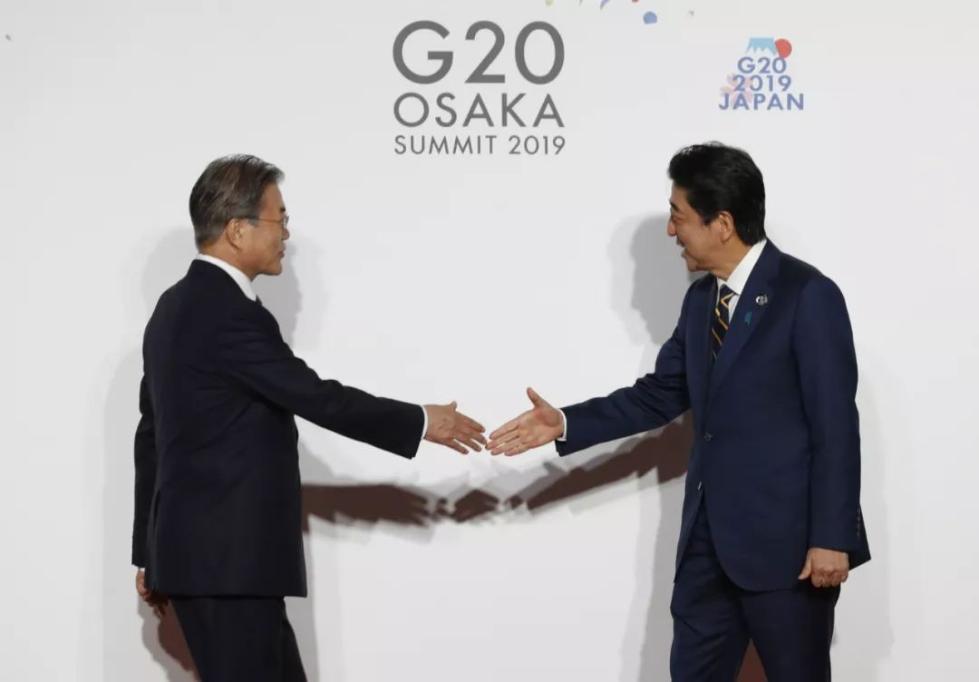6月28日，在日本大阪，日本首相安倍晋三（右）欢迎韩国总统文在寅。新华社发