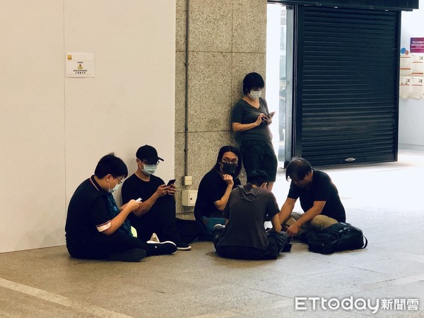 “黑衣人”坐在地上(图源：台湾“东森新闻云”)
