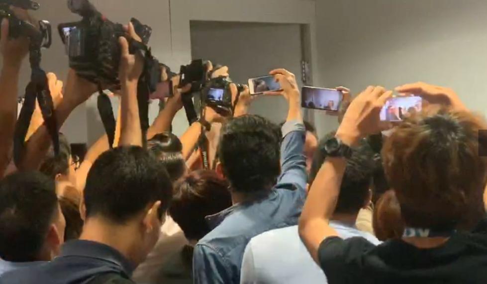 港媒记者将女记者团团围住。视频截图