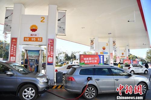 资料图：汽车在加油站加油。中新社记者 刘冉阳 摄