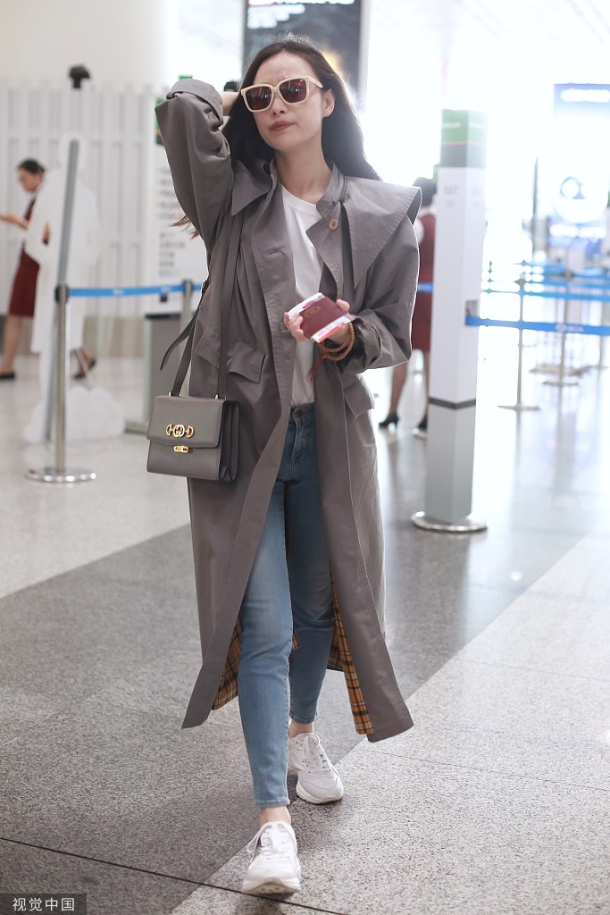 新浪娱乐讯 9月7日，北京，倪妮现身机场，她穿长款风衣英姿飒爽，撩发挥手大笑甜美可爱。