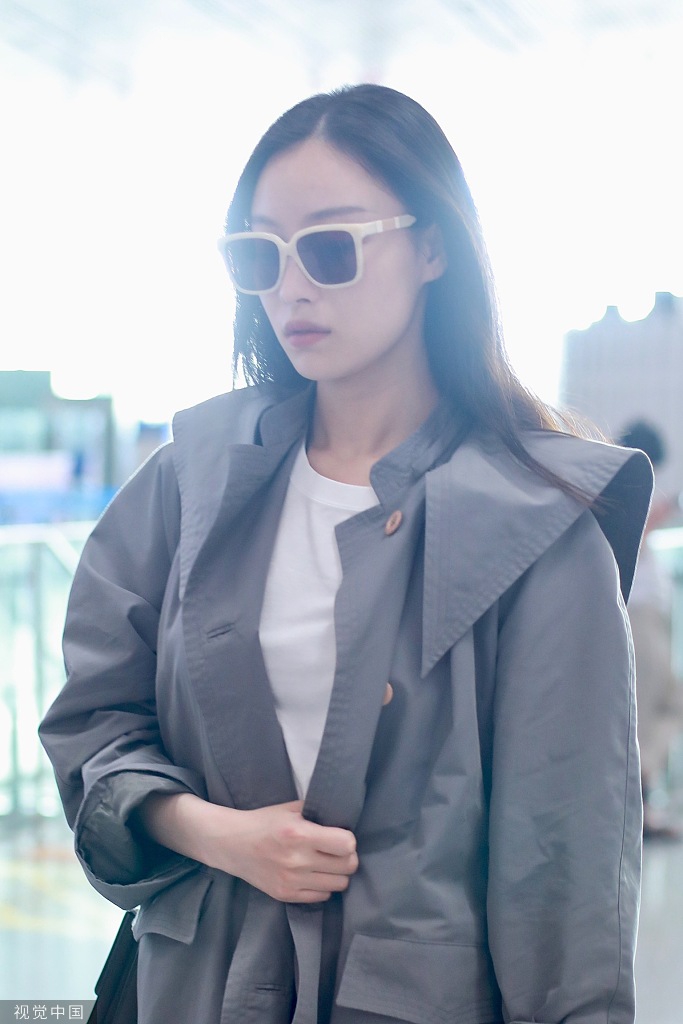 新浪娱乐讯 9月7日，北京，倪妮现身机场，她穿长款风衣英姿飒爽，撩发挥手大笑甜美可爱。