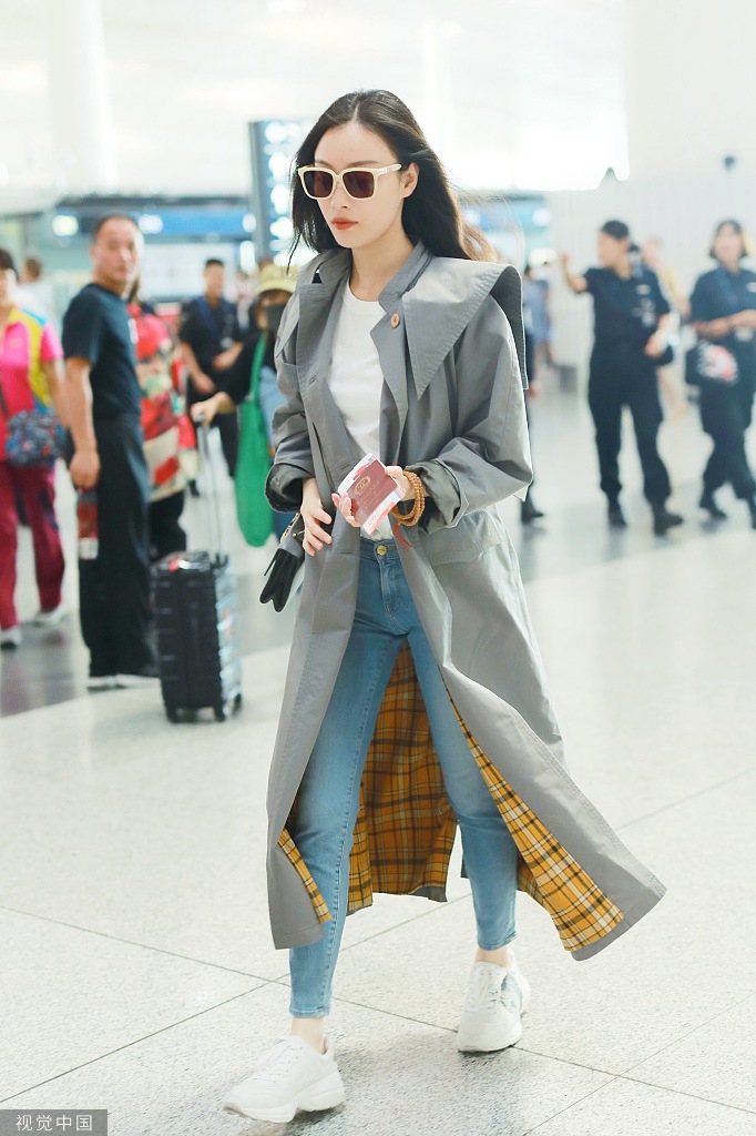 新浪娱乐讯 9月7日，北京，倪妮现身机场，她穿长款风衣英姿飒爽，撩发挥手大笑甜美可爱。