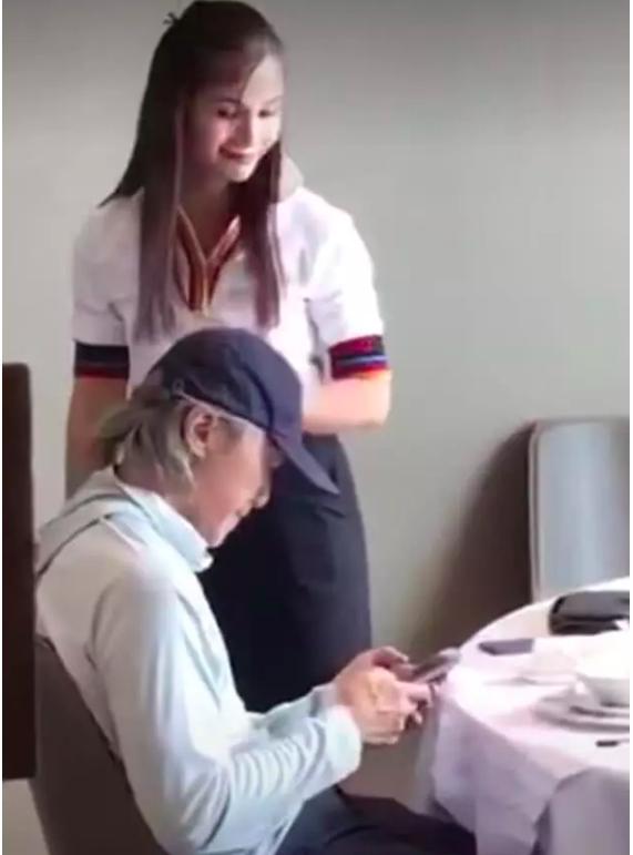 服务员似乎对星爷的手机内容有些好奇，还偷瞄了几眼。