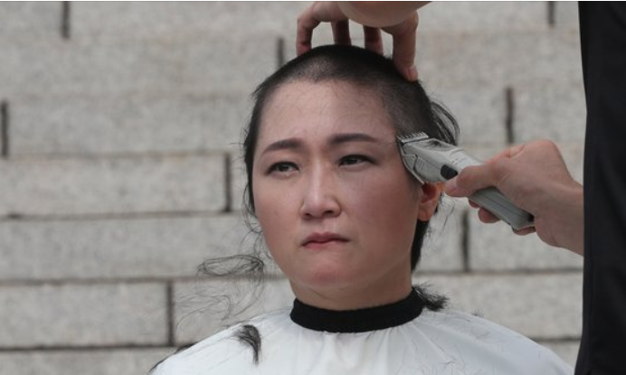 韩国女议员当众剃光头边哭边喊话文在寅道歉