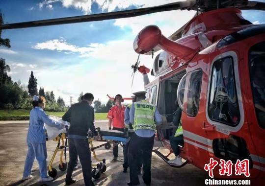 图为伤员被送上救援直升机。 云南高速公路交巡警支队供图 摄