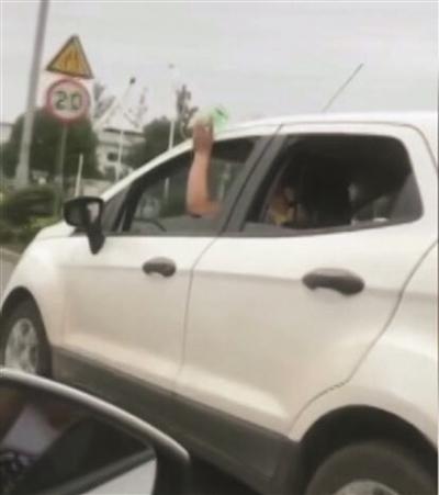 司机被拍到一手持吊瓶一手开车。视频截图