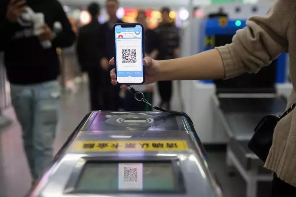 2018年12月1日，上海地铁人民广场站内，市民使用手机扫码进站。（新华社记者丁汀 摄）