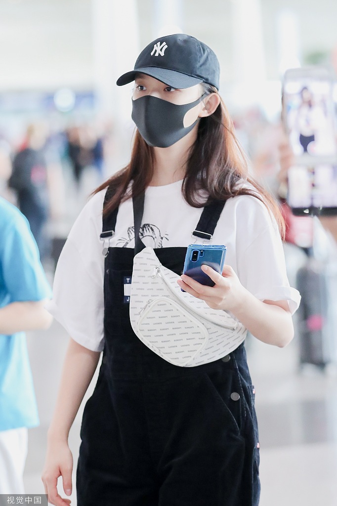 林允素颜戴帽子口罩包裹严实 穿背带裤玩手机呆萌十足