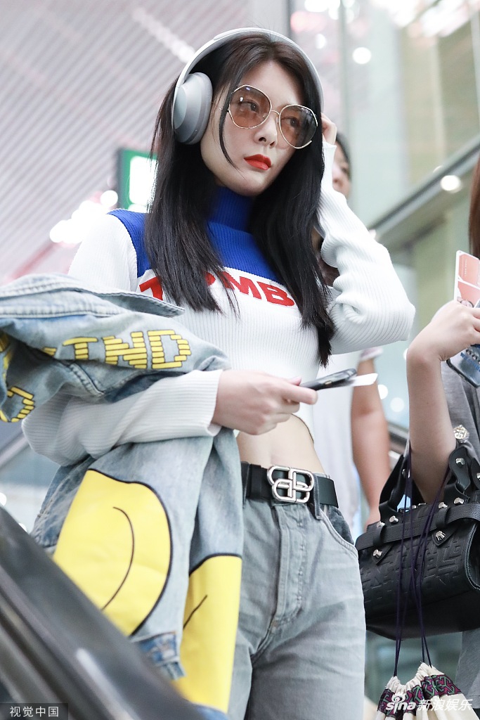傅菁戴大耳机穿露脐装现身机场气质高冷低头疾走秀蛮腰