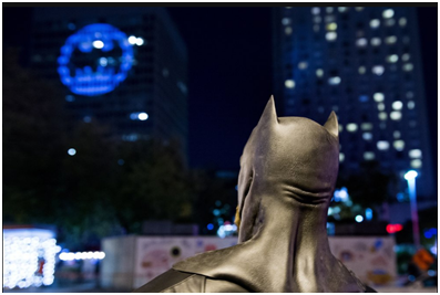 21日晚的蒙特利尔，粉丝装扮成蝙蝠侠模样，望着大楼上标志 图源：美联社