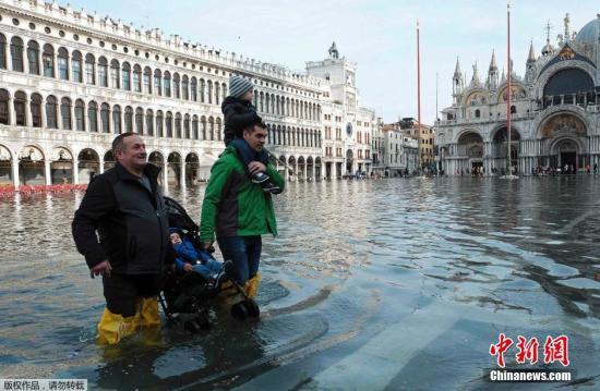 图为意大利威尼斯的圣马可广场被水淹没，游客游兴不减穿梭期中。