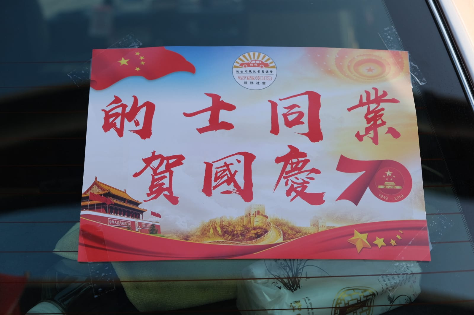 在巡游的出租车上贴有“的士同业贺国庆”的海报(图片来源：香港“橙新闻”)