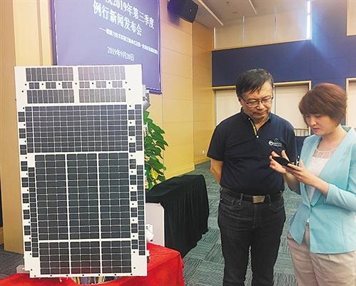 “太极一号”卫星工程总师王建宇(左)向记者介绍“太极一号”。