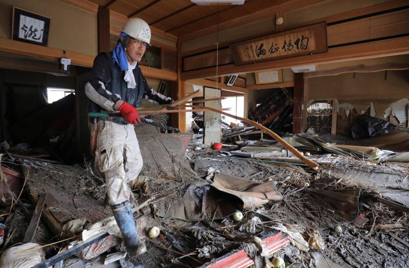 日本灾民在清理被洪水浸泡过的房屋（《每日新闻》）