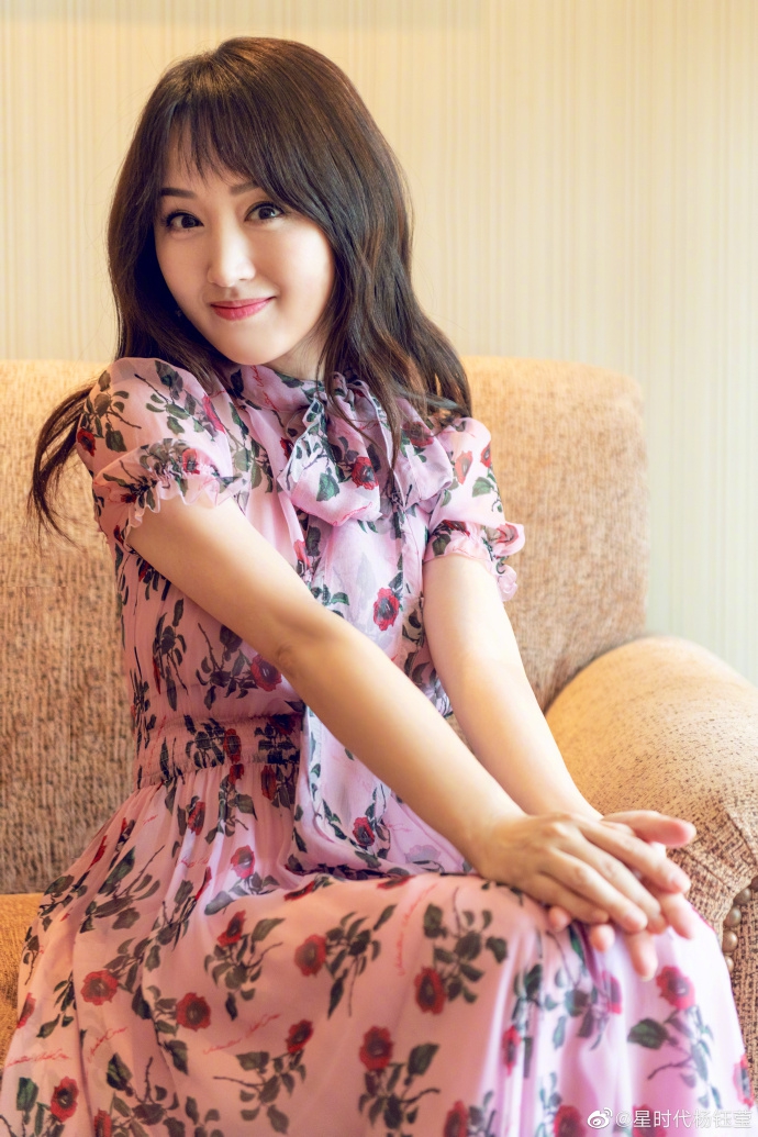 杨钰莹穿粉色印花长裙晒美照 低头撩发笑容甜美气质迷人