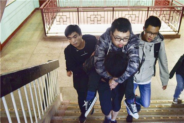 10月15日，湖南科技学院，同学背着黎际勤走楼梯。 图/受访者提供