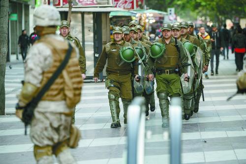 21日，智利军警在首都圣地亚哥街头警戒巡逻，以避免暴力抗议进一步升级。