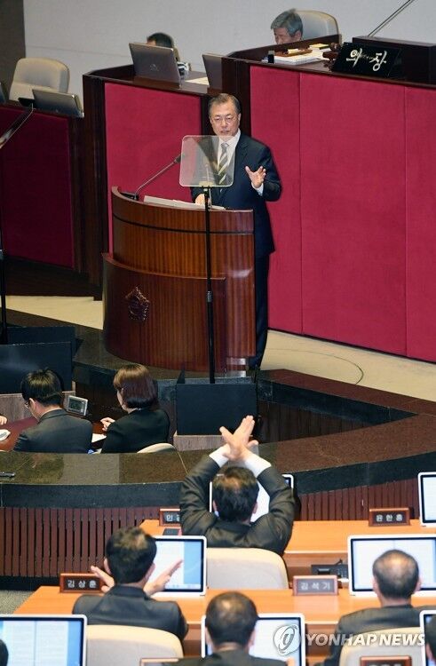 文在寅讲话时，有在野党议员做出“×”手势（图源：韩联社）