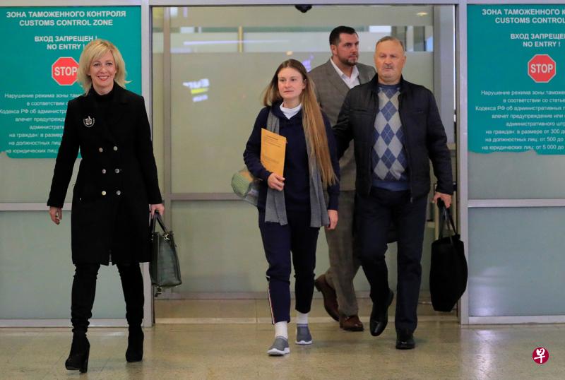 布京娜（中）在俄罗斯外交部发言人扎哈罗娃和父亲的陪同下，一起走出机场/图自《联合早报》