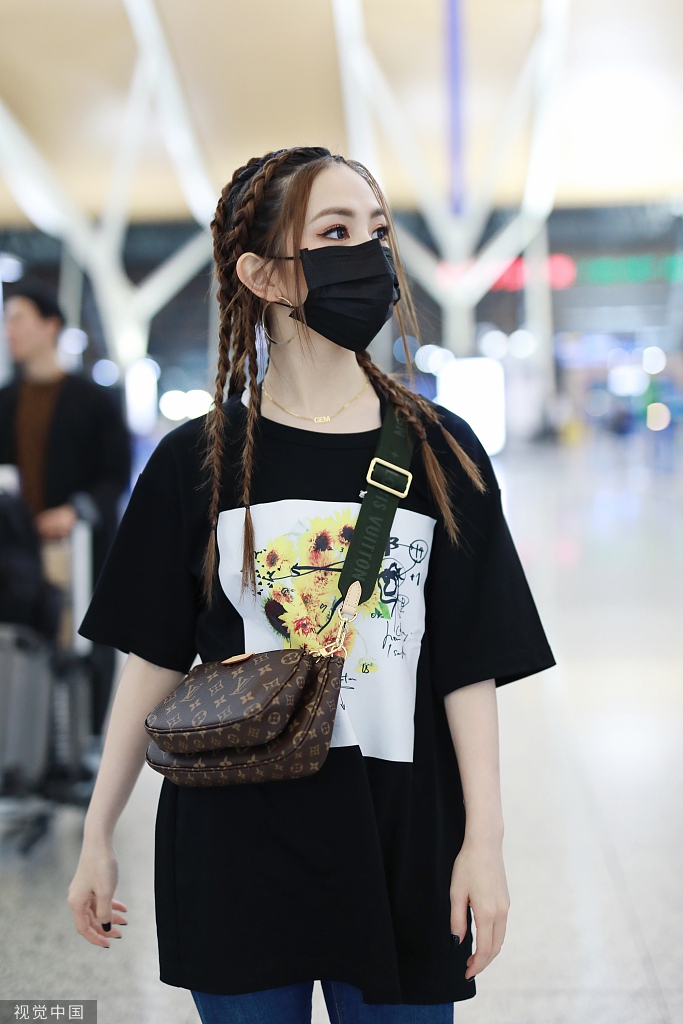 邓紫棋浓浓眼妆配辫子头现身机场男友风打扮干练