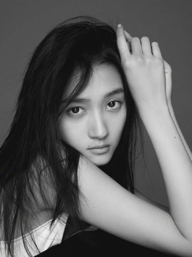 照片中,关晓彤身着白色背心,长发披肩,被风吹的有些凌乱,清澈的双眸