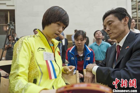 资料图：世界冠军张怡宁(左)在传授技艺。中新社发 陈钢 摄