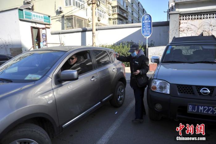 北京市某停车场管理员为车主指挥倒车。中新网记者 金硕 摄