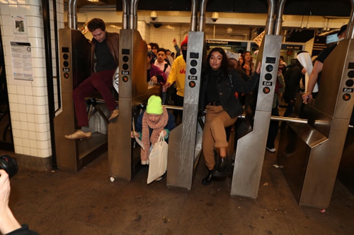 示威者翻过地铁站闸机。图源：《纽约邮报》 