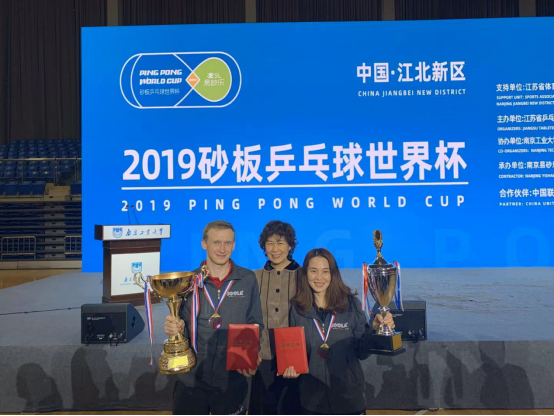 中国乒协副主席李一冰(中)与世界杯女单冠军陈婕和男单冠军佛莱明合影。邹吟寒摄