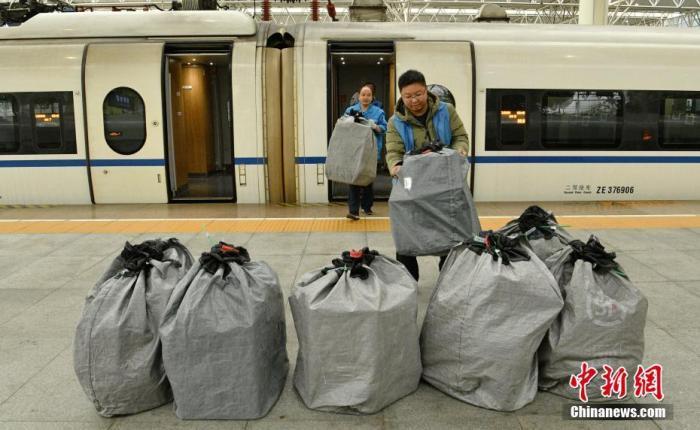 11月11日，高铁助力“双十一”电商黄金周运输需求。图为工作人员将快递包裹搬运下车。中新社记者 刘忠俊 摄