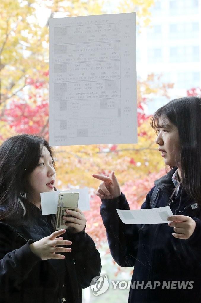 13日，韩国首尔两位女生正在确认考场。（韩联社）