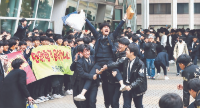13日，韩国首尔某学校高一高二的学生，为参加高考的前辈打气。（韩联社）