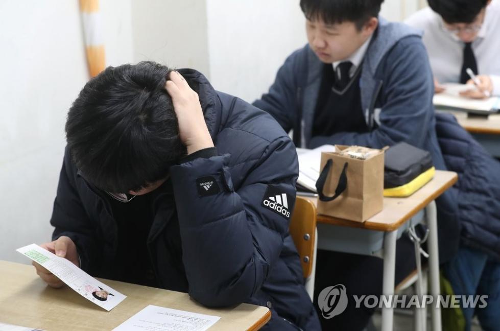 13日，在首尔龙山高中，学生查看准考证。 （韩联社）