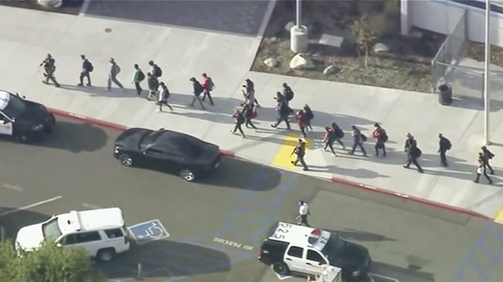 学生在警察护送下离开学校。图源：美联社