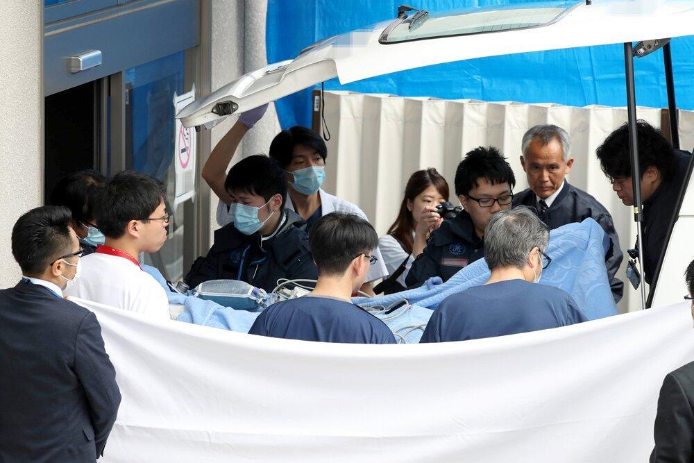 青叶真司躺在担架床上被运上救护车。图源：《京都新闻》