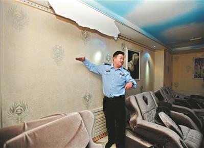 巨蟒藏身商铺天花板10年 六人合力用被子将其擒住