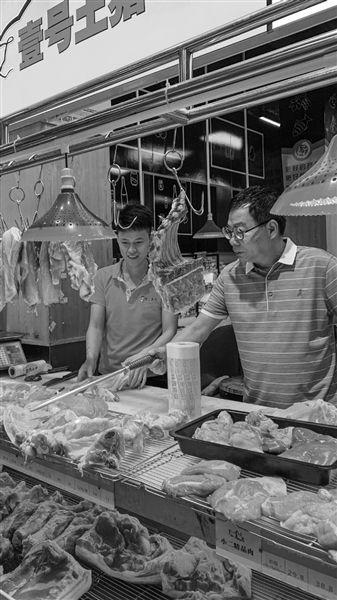 陆步轩(右)在自己的品牌猪肉门店。 受访者供图