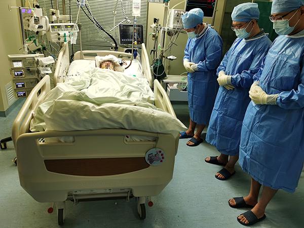 11月18日上午，器官获取前，医护人员向小韩默哀。受访者供图