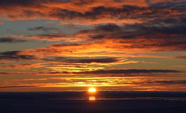 “雪龙”号进入南极外围浮冰区，从船上拍到的海上日落场景。澎湃新闻南极科考特派记者 何锴 图