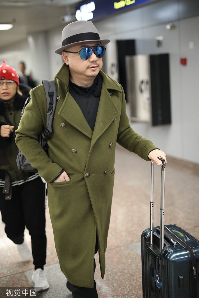 徐峥戴礼帽穿军绿色大衣现身 抿嘴快走霸气十足