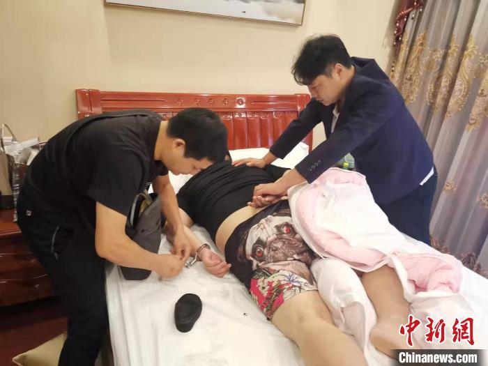 图为专案组民警在日租房内抓获犯罪嫌疑人。警方供图